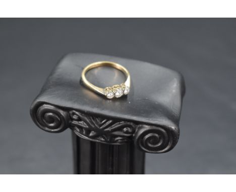 A diamond trilogy ring having three small diamonds in an illusionary mount on an 18ct gold loop, size N &amp; approx 1.9g