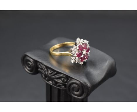 A multi cluster ring having a central diamond surrounded by six oval rubies in petal form within a further surround of twenty