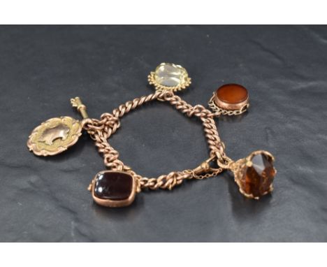 A 9ct rose gold curb link bracelet having four fob charms (one AF), a key charm and a medallion, approx 46.8g