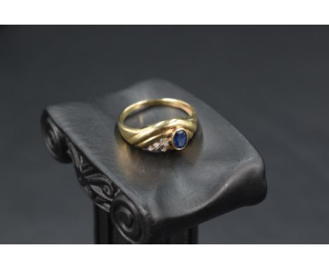 A 9ct gold moulded band ring having a collared sapphire with diamond chip decoration, size R &amp; approx 2.6g