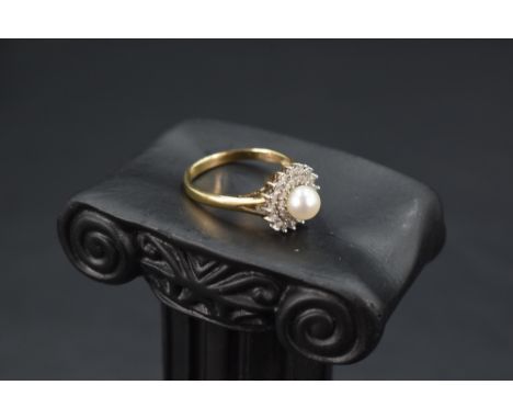 A cultured pearl ring having a double surround of diamond chips to open shoulders on a 9ct gold loop, size O &amp; approx 2.5