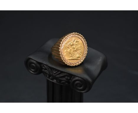 A gold sovereign coin ring, dated 1968 held within a geometrically cut bezel mount in a textured removable 9ct gold loop, spl