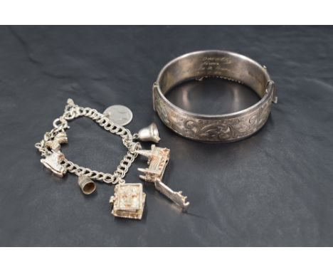 A silver hinged bracelet having engraved scroll decoration and inscription inside dated 1960, and a white metal fancy link ch