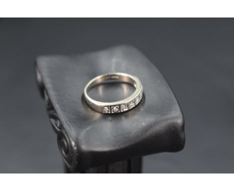 A white metal half eternity ring stamped 18ct having eight diamond chips in square mounts, size M &amp; approx 3.5g