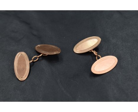 A pair of 9ct rose gold cufflinks having oval panels with engine turned decoration and link connectors, approx 6.7g