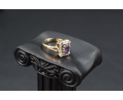 An amethyst ring having a diamond chip set rectangular surround to open shoulders on a 9ct gold loop, size N &amp; approx 3.3