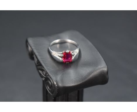 A baguette cut ruby ring approx 1ct in a claw set mount to diamond set split shoulders on a white metal loop stamped 18ct &am