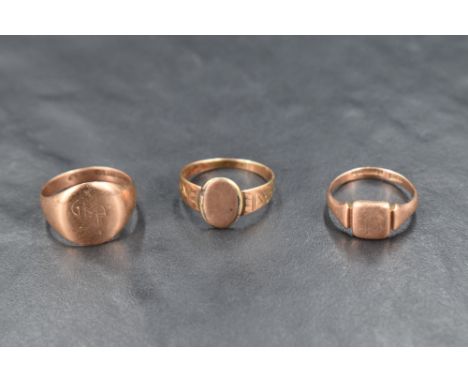 Two 9ct rose gold signet rings of worn form and a similar yellow metal signet ring, approx 9g total