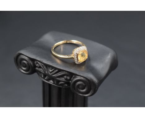 A facet cut citrine ring having a diamond halo surround, total approx 0.12ct in a basket style mount on a 9ct gold loop, size