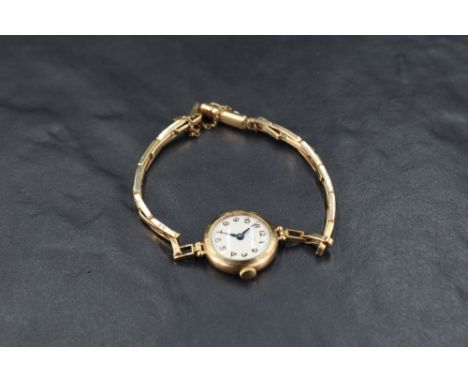 A lady's 9ct gold wrist watch by Rotary having an Arabic numeral dial to cream face in plain circular case with a 9ct gold fl
