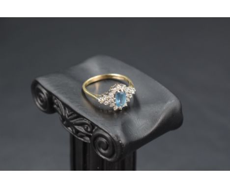 A blue topaz and diamond cluster ring flanked by a further trio of diamonds to each side, total approx 0.5ct, in a claw set b