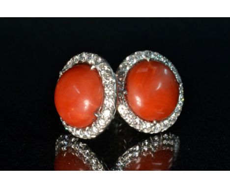 Chopard - a pair of diamond and red coral earrings, each with a central circular red coral cabochon surrounded by a band of t