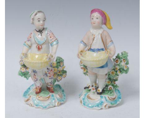 A pair of Derby Patch Mark  figures, Dessert Gardeners, he in a  stocking cap, smock and blue apron,  she with a floral dress