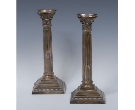 A pair of George III style silver Corinthian column table candlesticks, detachable nozzles,  stop fluted columns, stepped bas
