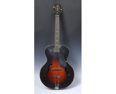 A vintage S.S. Stewart arch top acoustic guitar. model 4008, sunburst and faux flame finish, black pickguard affixed to the b