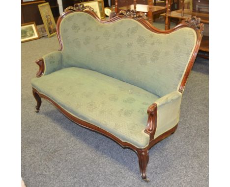  A 19th century mahogany sofa, the shaped back with ribbon tied cresting, scroll arms, French cabriole legs, fitted casters, 