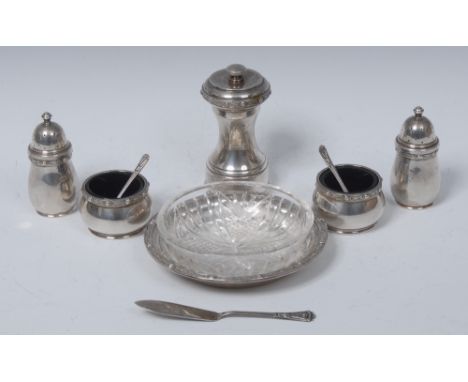 An Arts and Crafts style silver four piece cruet, comprising a pair of peppers and a pair of salts, each applied with a borde