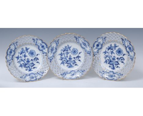 Three Meissen Onion pattern shaped circular plates, in underglaze blue, pierced basketwork borders, gilt line rims, 20cm diam