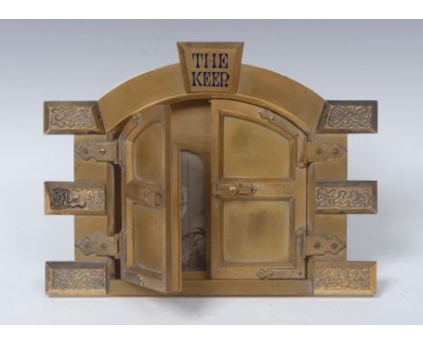 A Victorian gilt brass novelty photograph frame, The Keep, in the form of a castle gateway, the doors enclosing four aperture