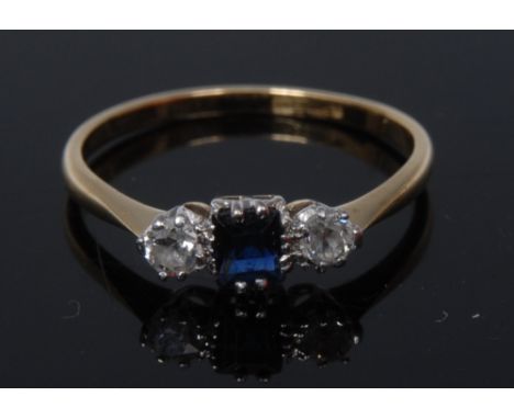 An Art Deco style diamond and sapphire ring, central emerald-cut stone flanked by a pair of round-cut diamonds, platinum claw