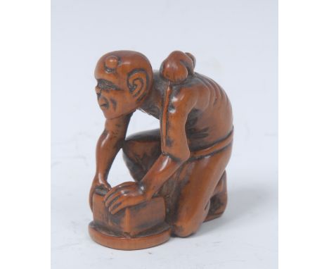 A Japanese boxwood netsuke, carved as a workman, kneeling, a rat on his back, 4cm high, signed, Meiji period   Condition Repo