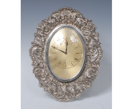 A substantial Victorian silver shaped oval strut clock, 8.5cm gilt engine turned dial with Roman numerals, the border embosse
