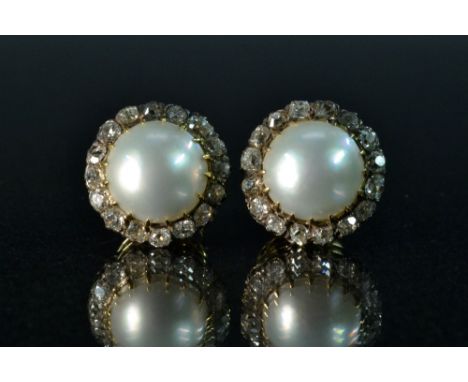 A pair of large pearl and diamond stud  earrings, each centred with a silver white half-pearl within sixteen rough and old cu