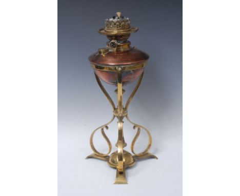 An Arts and Craft copper and brass oil lamp, the copper reservoir supports on sinuous brass frame, triform base, 44cm high, c