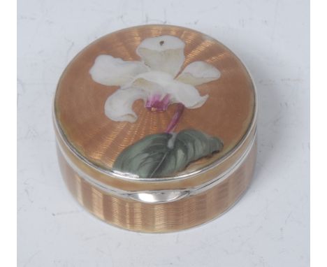 An Austrian silver and enamel circular snuff box, hinged cover decorated with a lily on a pale gold engine turned ground, gil