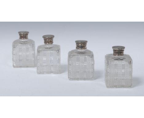A set of four 19th century silver coloured metal mounted hobnail-cut clear glass square cologne bottles, engine turned screw-