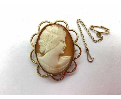 A Carved Shell Cameo Panel Brooch, the oval panel depicting the portrait of a lady, within openwork scalloped surround, stamp