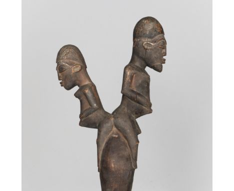 Burkina Faso, Lobi, a carved wooden handle of an adze, toped by a male and female figure. L. 70,5 cm. [1]