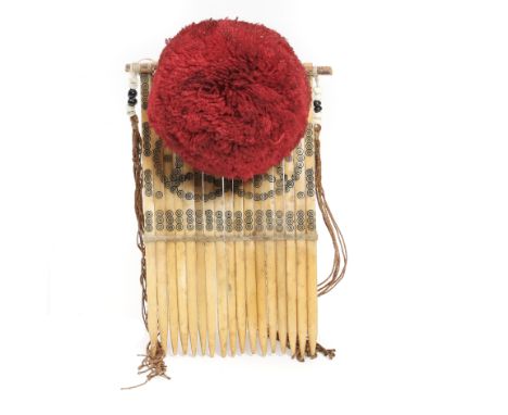 China, Yao, a bone comb with fringes partly beaded, a red wole pummel and engraving. h. 14 cm. [1]