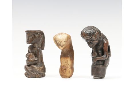 Bali, a wooden kris hilt, 19th century, shaped as a crouching figure holding an implement below the chin. Herewith a Central 