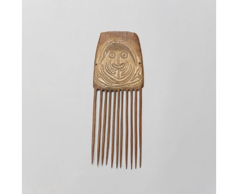Papua New Guinea, Papua Golf, a wooden comb with one side decorated with spirit figure in low relief.  L. 27 cm. Provenance: 