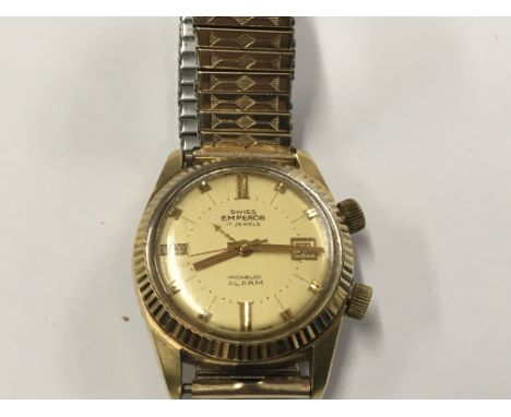 A Vintage Swiss Emperor Watch, Incabloc Alarm, 17 Jewel. The watch with a champagne dial raised battons, date aperture is in 