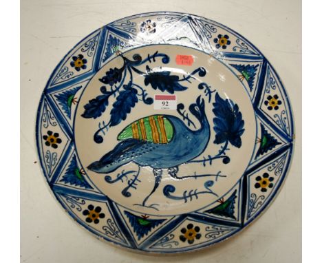 An 18th century Dutch Delftware charger decorated with a bird amongst foliage