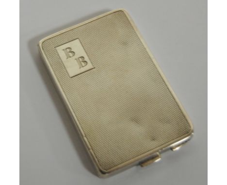 An Art Deco silver ladies powder compact, having an engine turned exterior, typical hinged action, with mirrored interior, ma