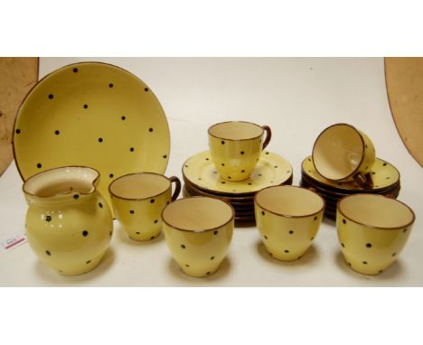 A rare Devonware part tea service, decorated with black polka dots on a yellow ground, comprising; six teacups, saucers, side