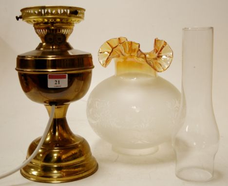 An early 20th century brass oil lamp with a frilled glass shade