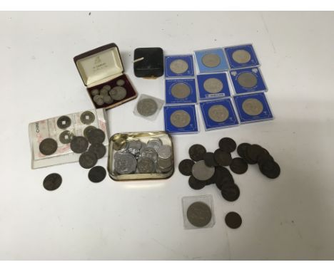 A box containing a collection of coinage and commemorative coin medals, including British and Chknese coins. Some loose stamp