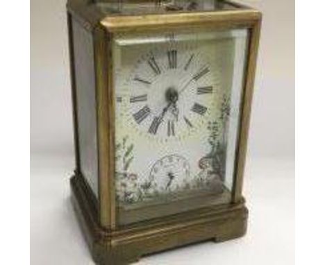 A brass carriage clock with painted clock face depicting cherubs and having a subsidiary dial, approx 15cm x 9cm x 7.5cm.