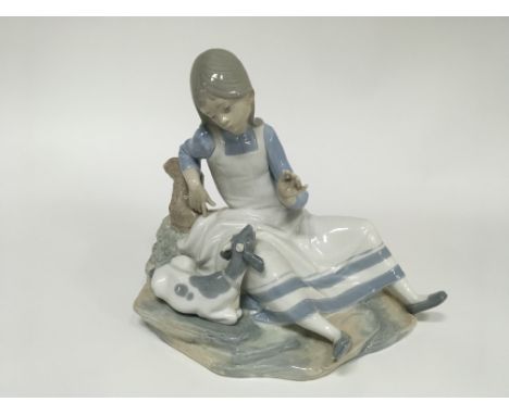 A NAO figure of a young girl with a small goat. Height approx 25cm.