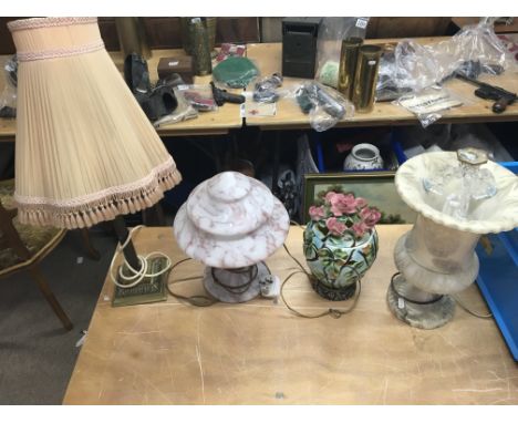 A group of four table lamps, including one ceramic lamp with a floral design.