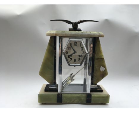An Art Deco mantle clock with a bird mascot atop, pendulum included.