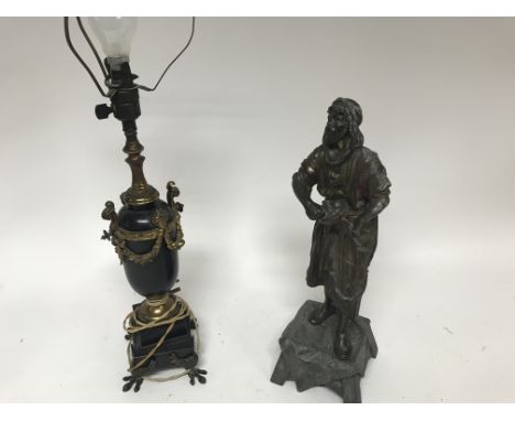 An interesting gilt metal table lamp, possibly Bergman style and a spelter figure of an enthusiastic street performer with a 