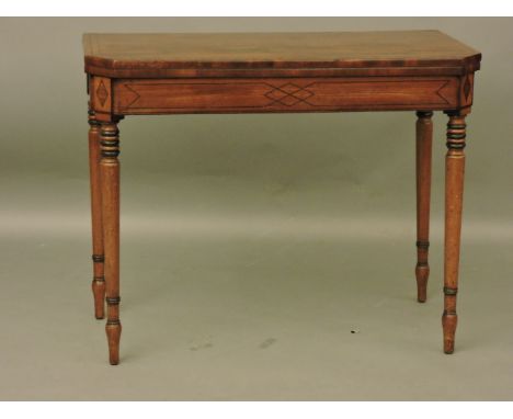 An early 19th century mahogany card table, with ebony stringing on turned legs, 91.5cm, 74cm high