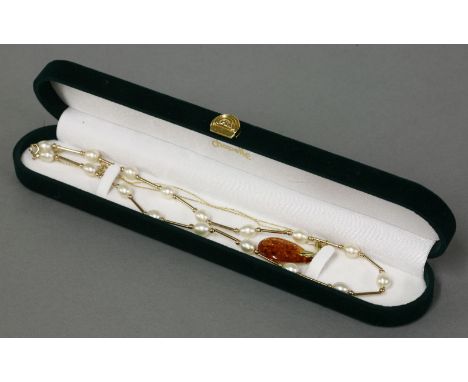 A gold mounted amber pendant and chain, marked 375, and a cultured freshwater pearl, gold tube and gold bead necklace marked 