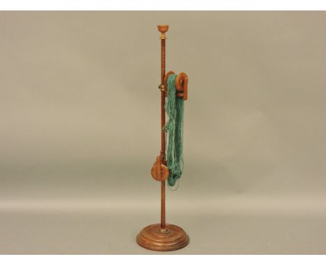 A 19th century mahogany free standing wool winder, with two reels, on a brass mounted clamp and pole stand, surmounted by a b