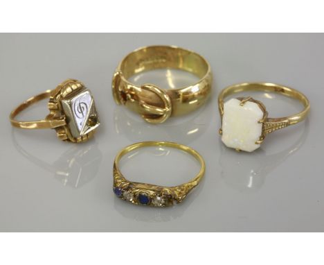 A 9ct gold garnet set buckle ring, a single stone opal ring marked 9ct, a boat shaped ring set with two diamonds and a sapphi